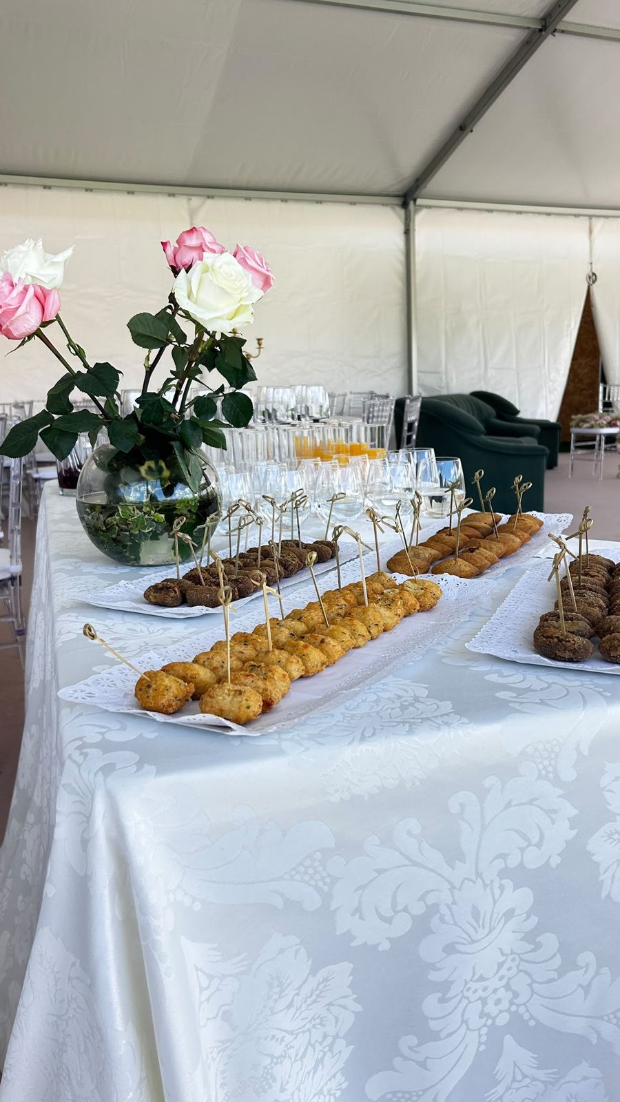 Salgados de boas-vindas servidos numa mesa com rosas
